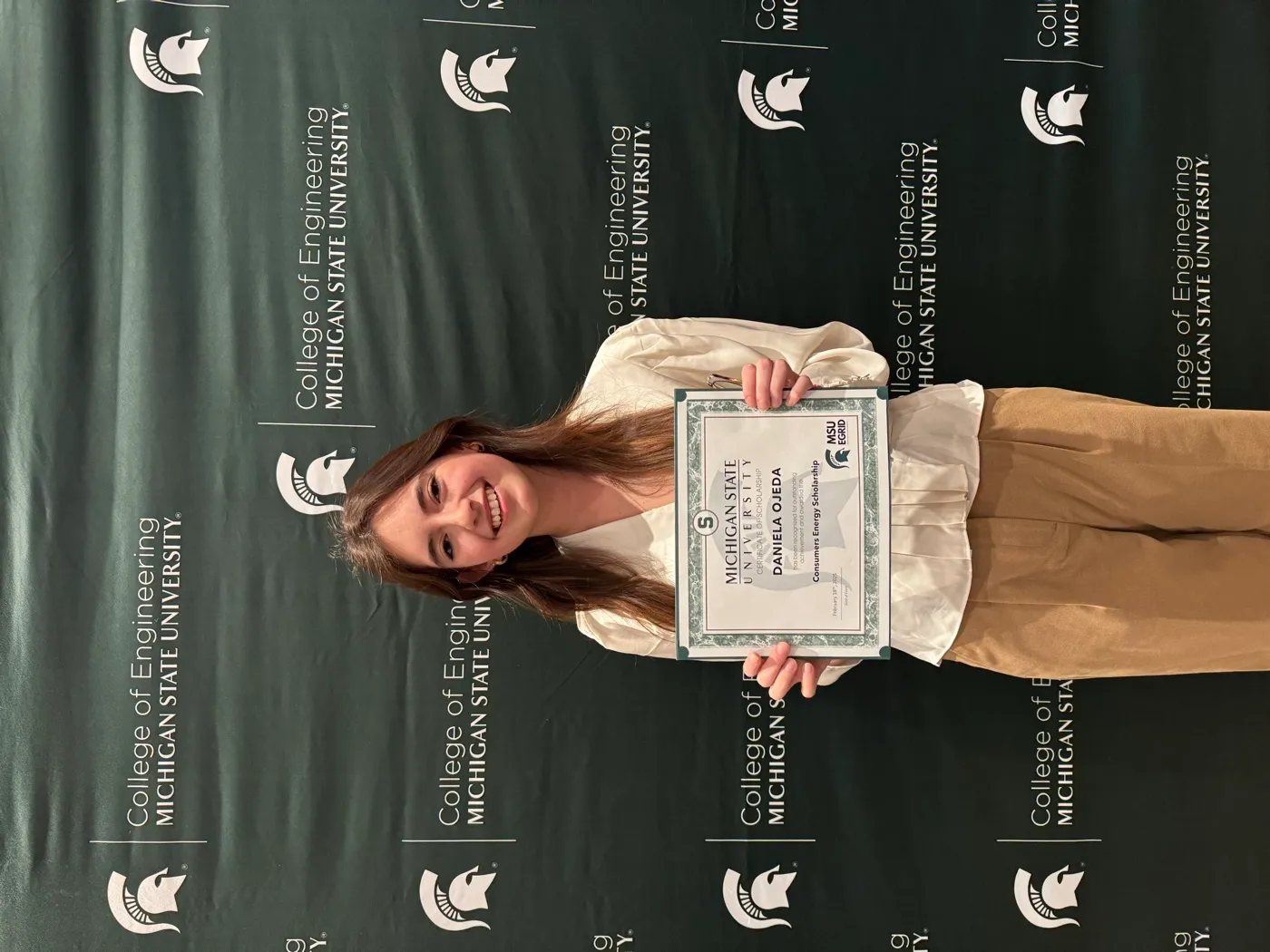 Daniela holding a scholarship certificate at an MSU College of Engineering recognition event